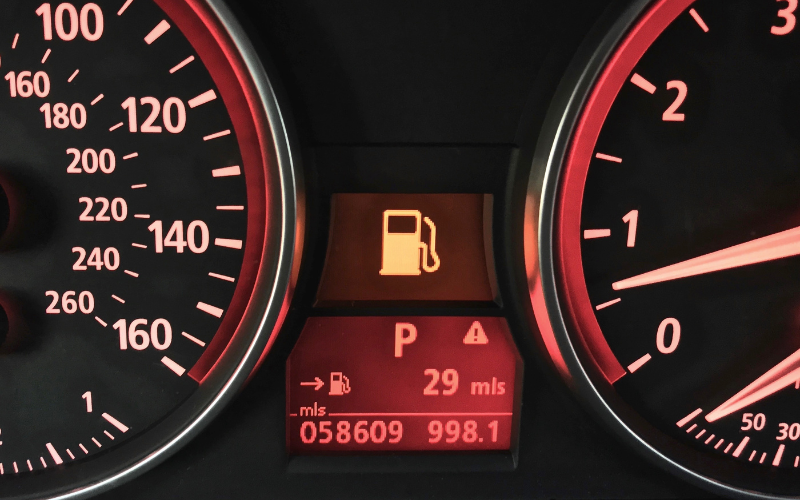 Close-up of a car driver's display showing fuel warning light