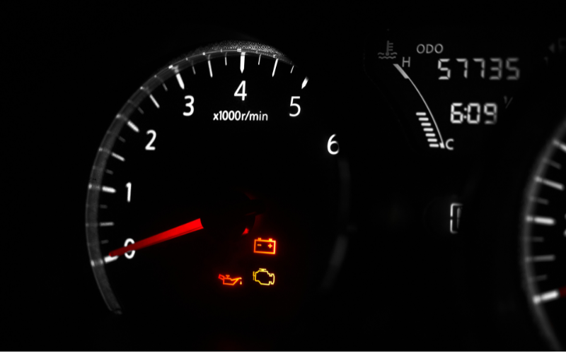 Close-up of a car driver's display showing oil, engine, and battery warning lights